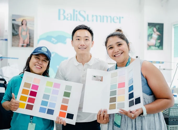 Client and Bali Summer team smiling while holding the best fabrics option for swimwear in 2026 inside Bali Summer’s office